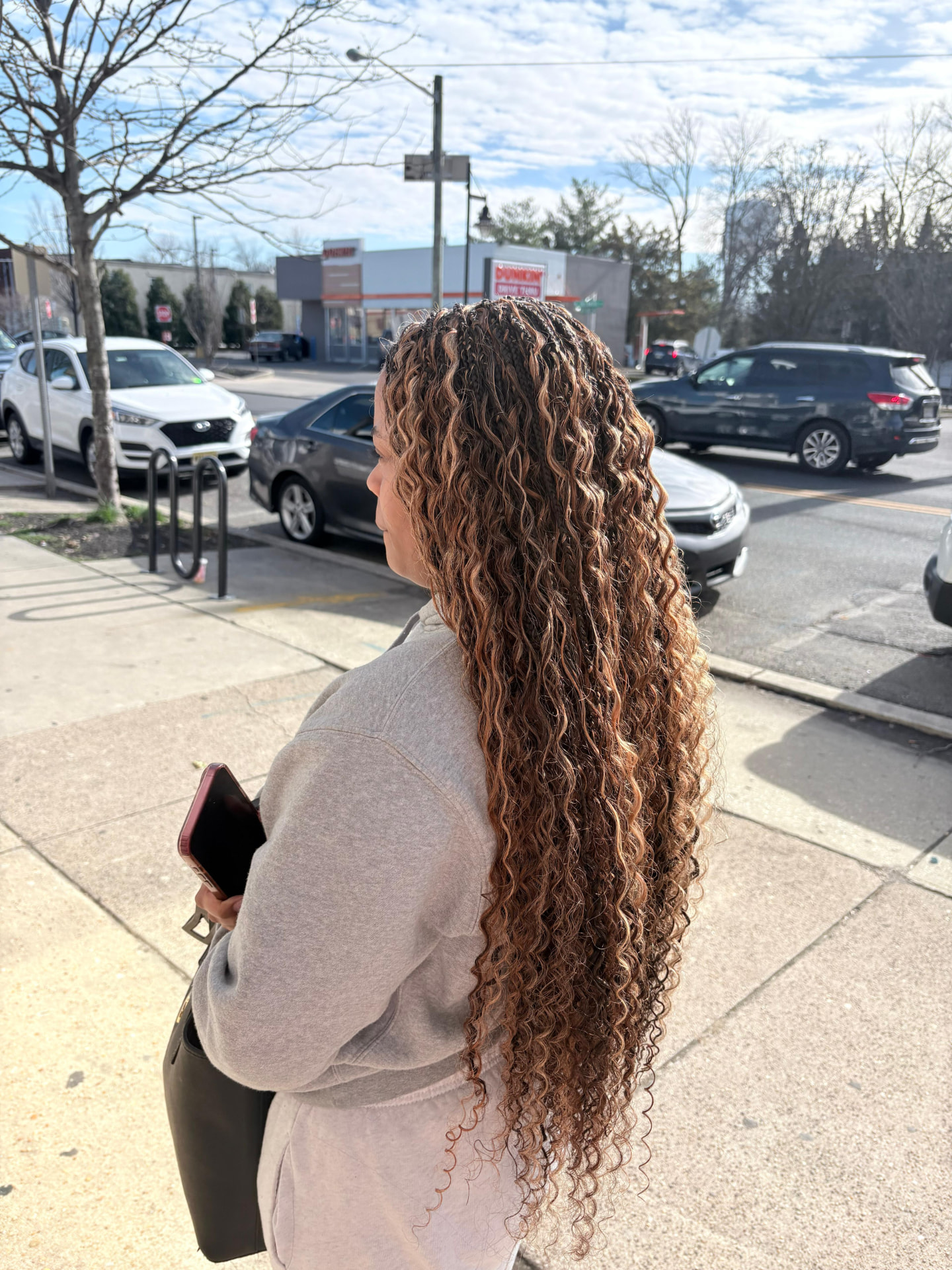 Client with long goddess boho braids blended with flowing curls, shown outdoors